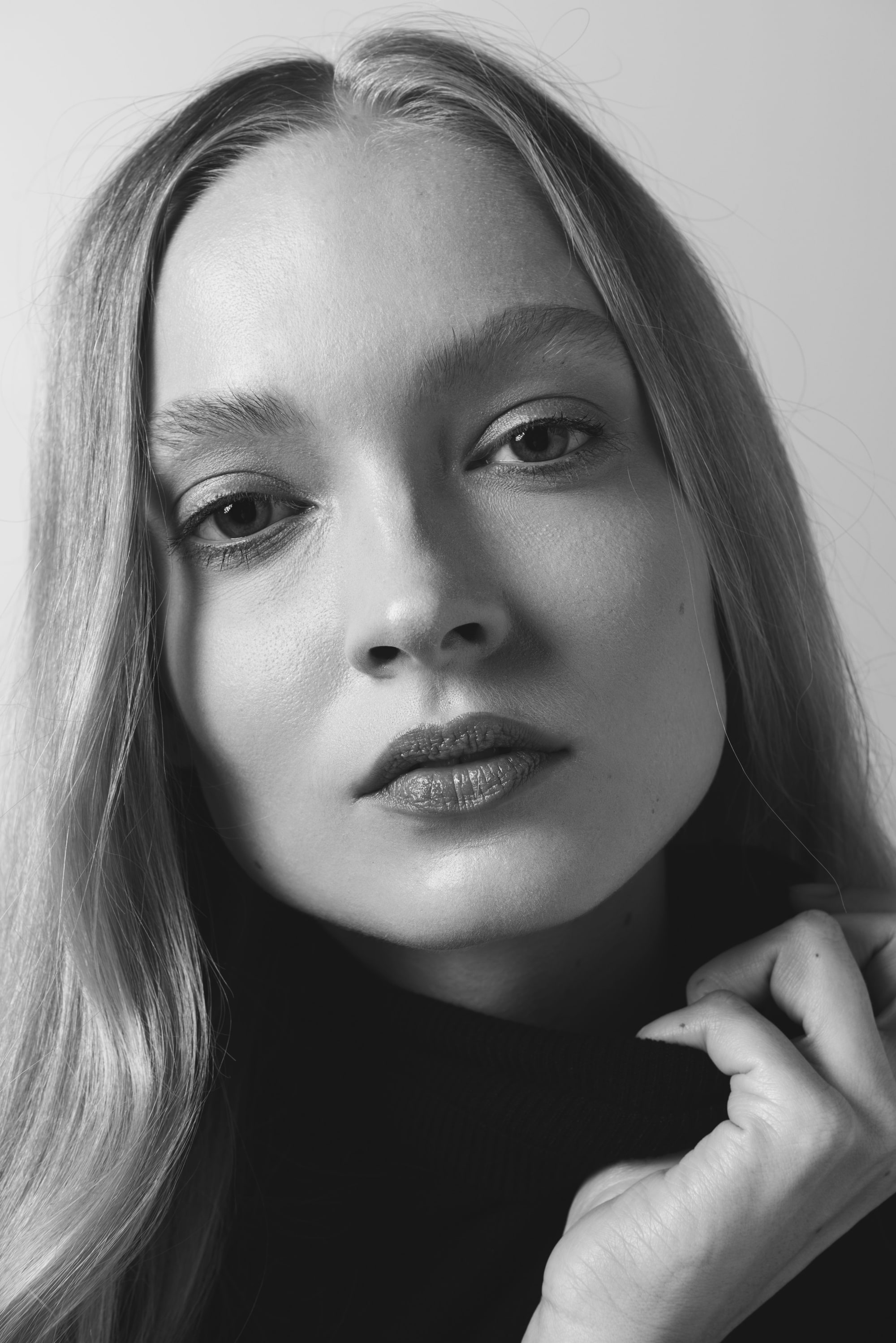 Nikita Lauffer in a black turtleneck, one hand at her collar