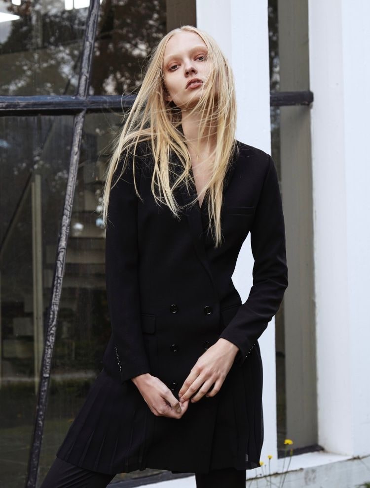 Nikita Lauffer in a black double-breasted blazer by a window