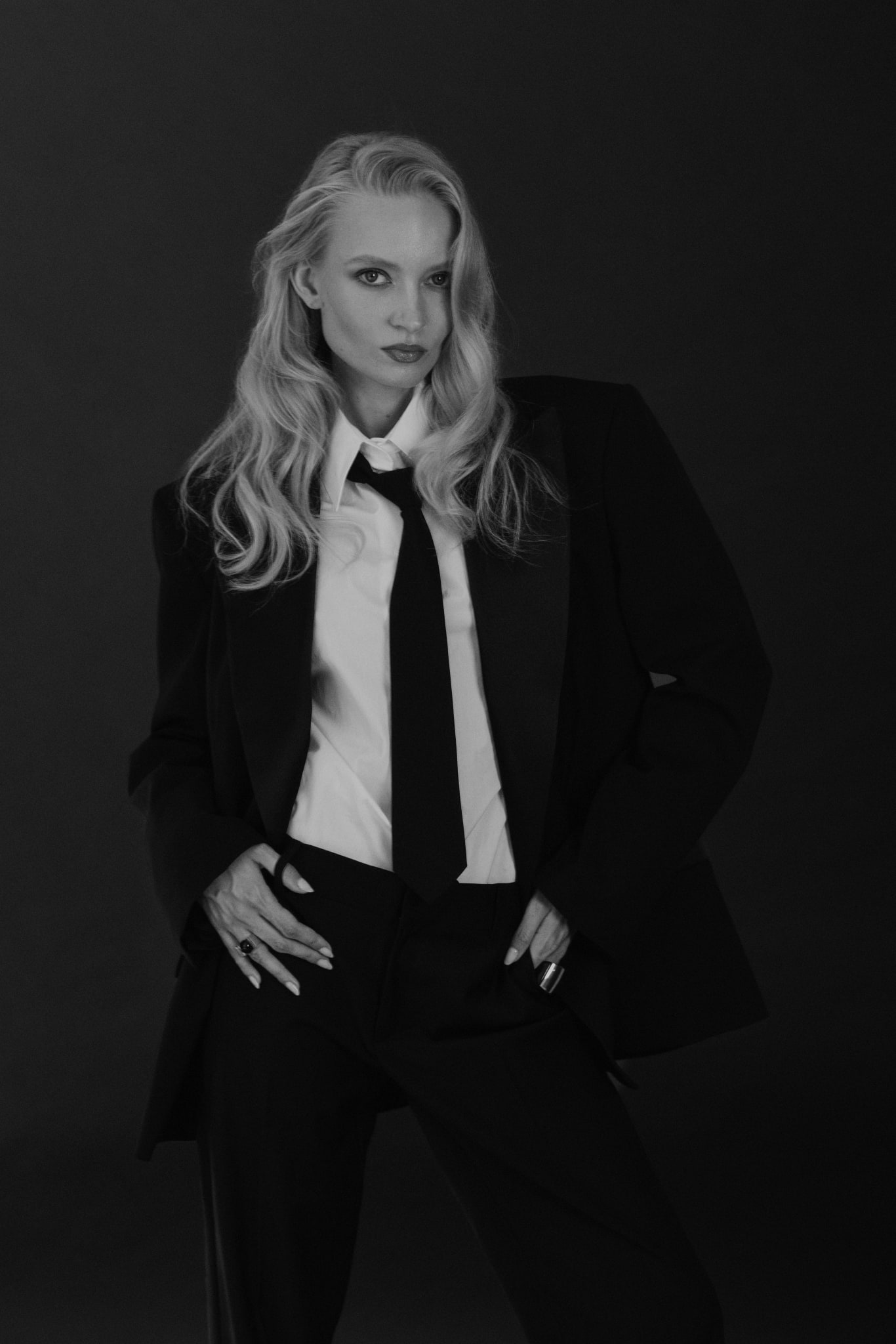 Nikita Lauffer in a black suit, white shirt and tie, black and white